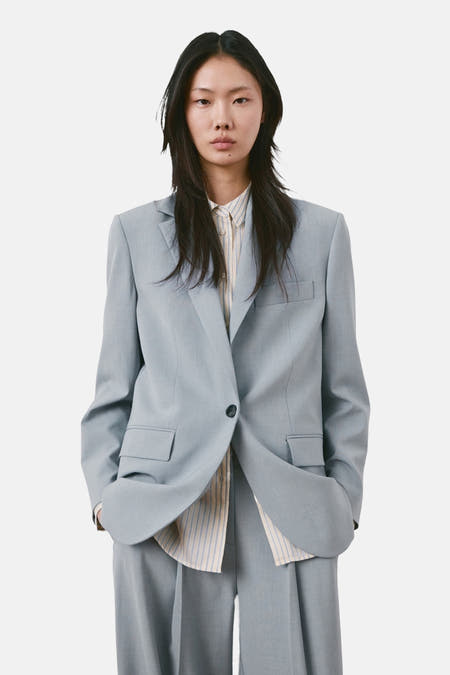 Blazer bleue de MANGO, vue de dos, avec col à revers et poches passepoilées.