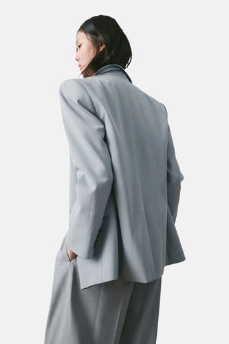 Blauwe blazer van MANGO, gezien van achteren, met reverskraag en ingezakte zakken.