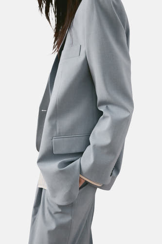 Blazer bleu de MANGO, avec un revers classique et des poches plaquées, dans un style décontracté.