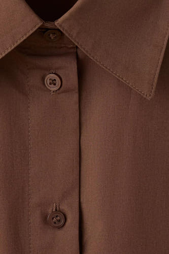 Chemise marron de MANGO avec col et boutons, gros plan sur la texture du tissu.