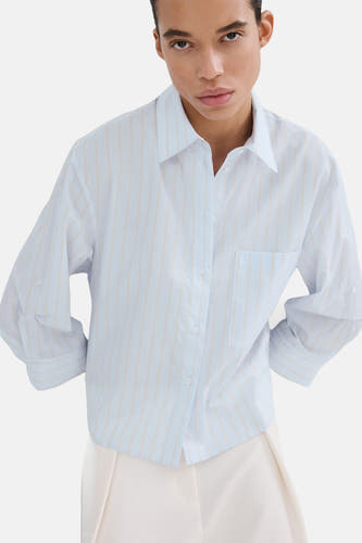 Chemise bleue rayée de MANGO, à manches longues et poche poitrine, déboutonnée.