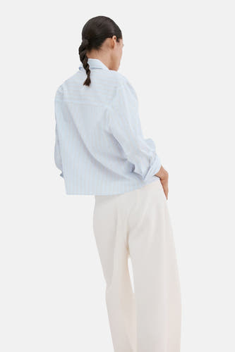 Chemise bleue rayée (manches longues) de MANGO, avec manches retroussées et col montant, dos.