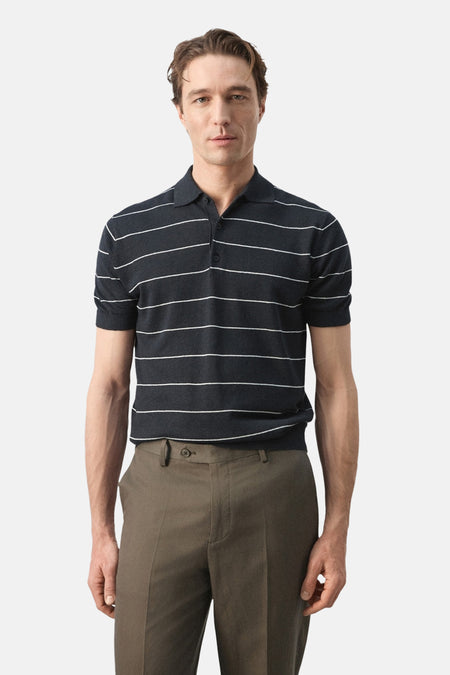 Polo noire de MANGO à motif rayé, portée avec un pantalon vert olive, vue de dos.