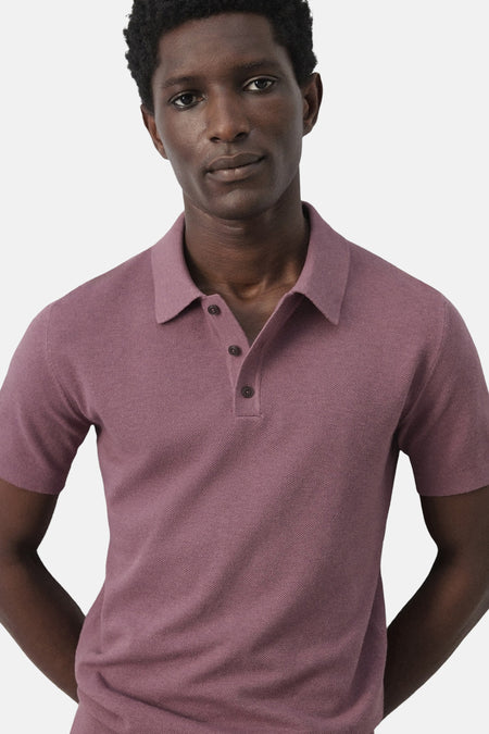 Polo violet MANGO, à manches courtes et fermeture boutonnée, présentée sur un mannequin sur fond uni.