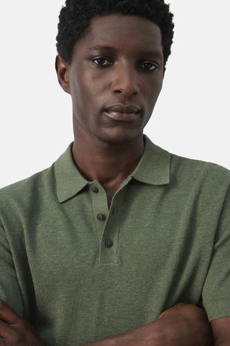 Polo verte MANGO de couleur verte, à manches courtes et à la coupe ajustée, portée par un homme.