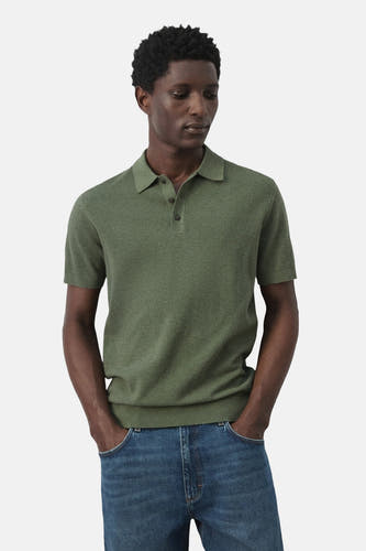 Polo verte MANGO de couleur verte, à manches courtes et col classique, portée avec un jean.