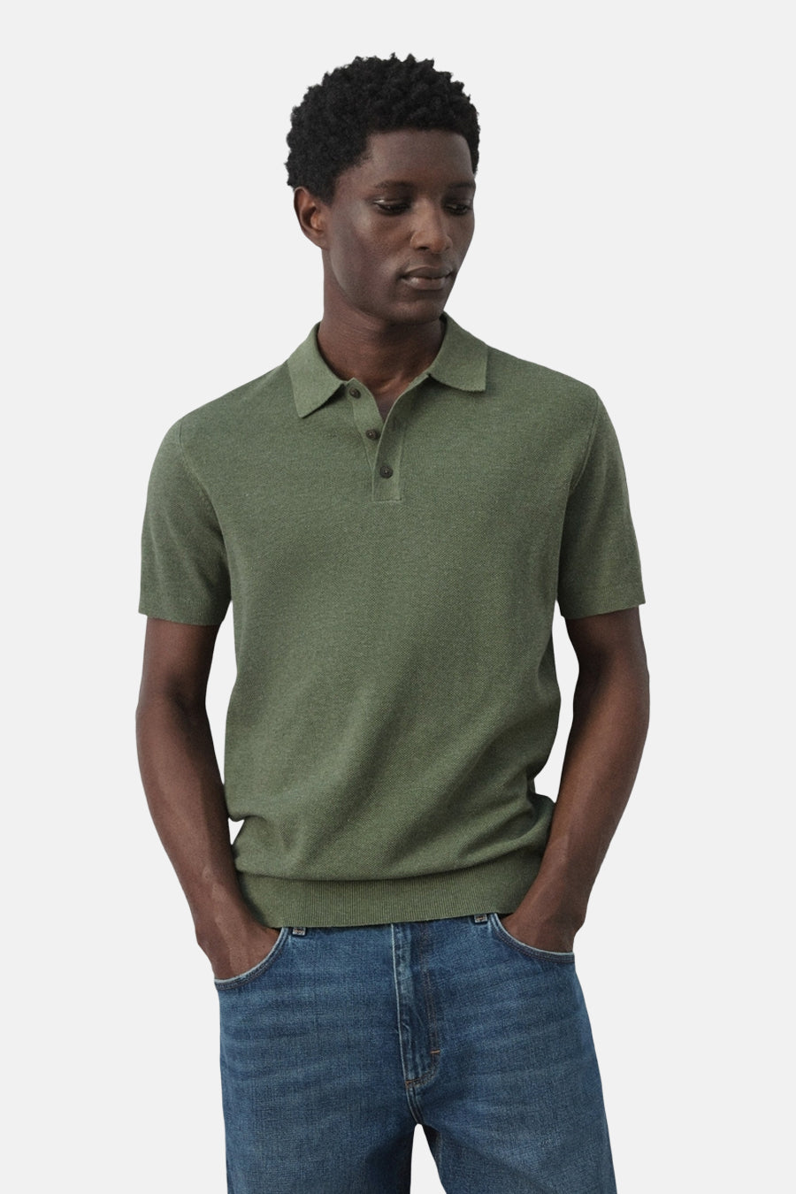 Polo verte MANGO de couleur verte, à manches courtes et col classique, portée avec un jean.