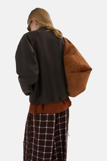 Blazer marron de MANGO, à manches longues et coupe décontractée, porté avec un pantalon à carreaux.
