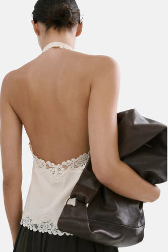 Ecru top zonder mouwen van MANGO met halterhals en open rug met kanten afwerking, gedragen met bruine tas.