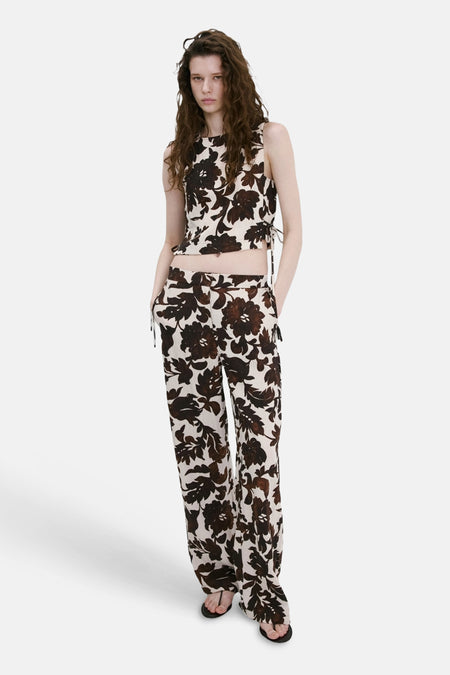 Haut court sans manches de couleur crème avec imprimé fleuri marron de MANGO, avec cordons de serrage, combiné avec un pantalon large assorti.