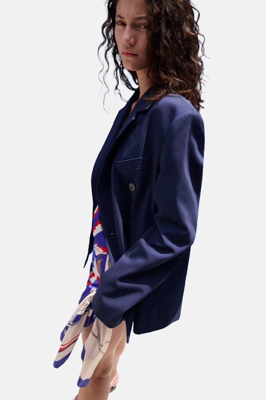 Vue latérale d'un blazer bleu croisé MANGO, porté sur un haut à motif nautique coloré.
