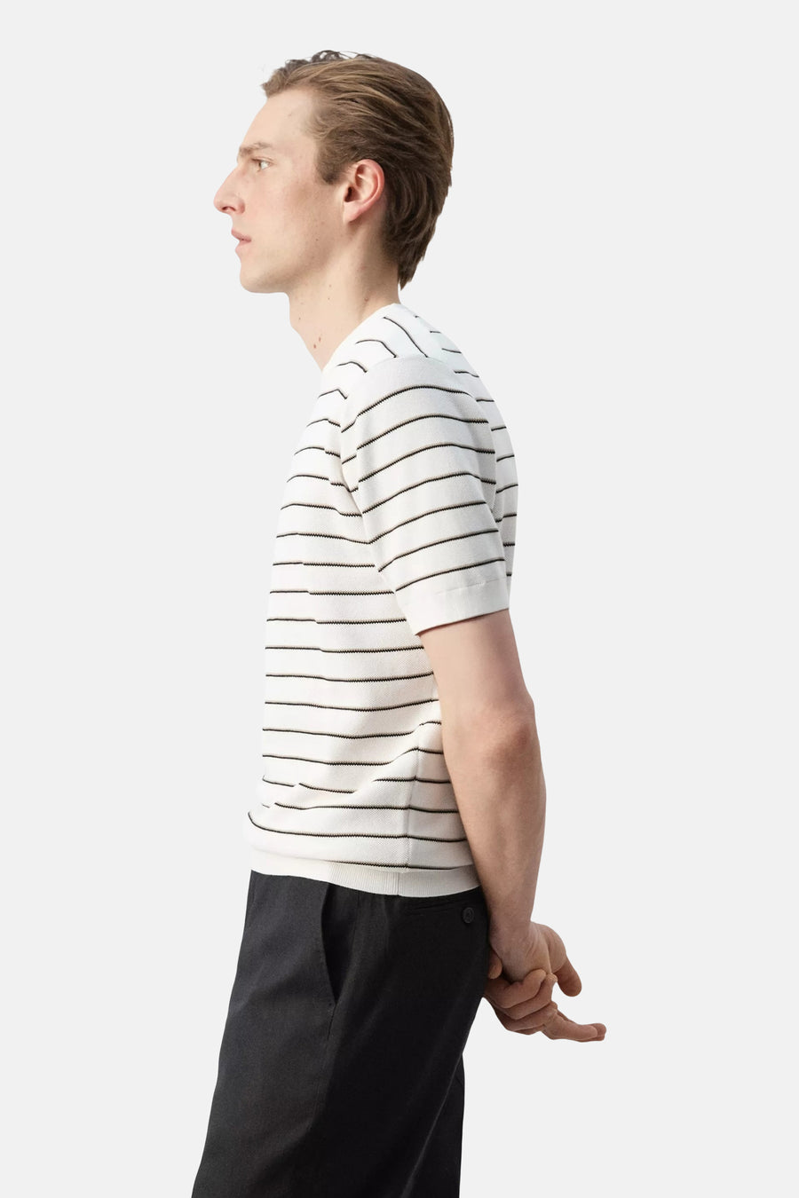 T-shirt blanc à fines rayures horizontales noires et beiges de MANGO, porté de profil.