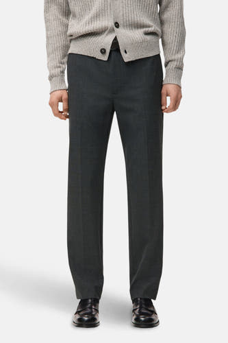 Pantalon gris de MANGO, vu de l'arrière, associé à un pull tricoté et des chaussures noires.
