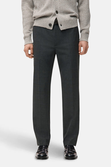 Pantalon gris de MANGO, vu de l'arrière, associé à un pull tricoté et des chaussures noires.
