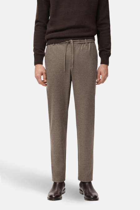 Pantalon marron de MANGO, avec une ceinture élastique et des poches à rabat à l'arrière, vu de derrière.