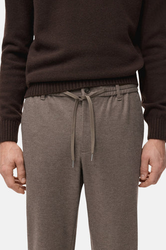 Bruine trui en grijze joggingbroek.