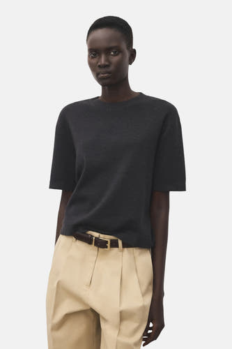 Sweat-shirt gris avec col rond de MANGO, vu de derrière, associé à un pantalon beige et une ceinture.