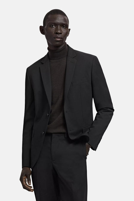 Blazer noire de MANGO, vue de dos sur un mannequin masculin portant un col roulé et un pantalon assorti.