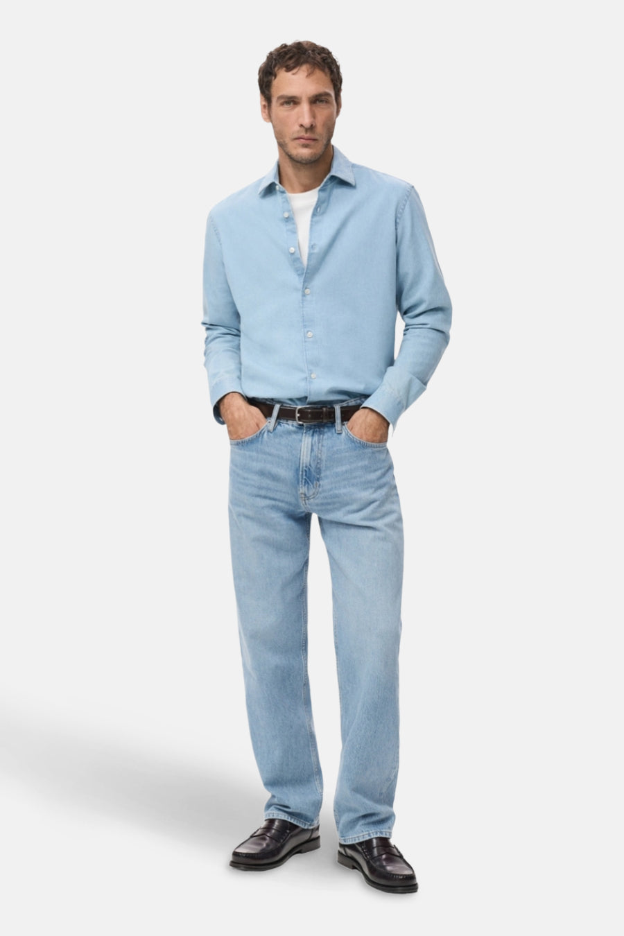 Jean en denim bleu clair droit de MANGO, porté avec une ceinture marron et des loafers en cuir.