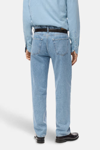 Lichtblauwe straight jeans van MANGO, gezien van achteren, met een zwarte riem en zwarte schoenen.

