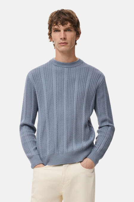 T-shirt bleu avec col rond de MANGO, en côtes sur le dos et en pantalon crème.