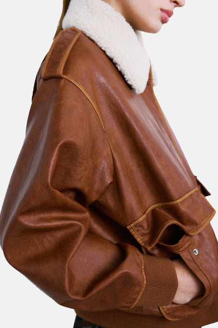 Veste courte marron de MANGO avec col en fausse fourrure, poignets côtelés et détail de poche à bouton, vue de côté.