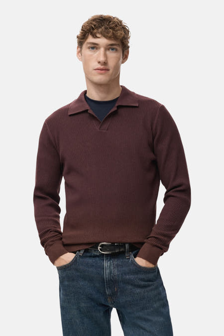 Pull à col V Bordeaux de MANGO, avec des fines côtes et porté avec un jean bleu foncé.