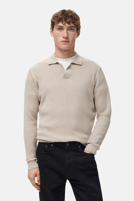 Gilet V encolle beige de MANGO, avec une texture côtelée, vu de l'arrière, associé à un pantalon noir.