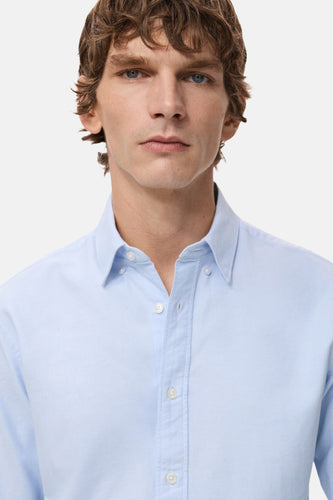 Man in lichtblauw overhemd.
