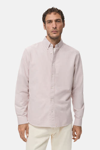 Chemise rose à manches longues de MANGO, vue de derrière, avec un pantalon crème et des chaussures noires.
