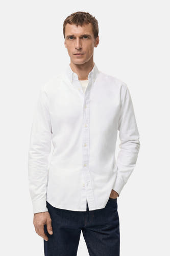 Blouse blanche à manches longues de MANGO, vue de derrière, avec des jeans foncés.