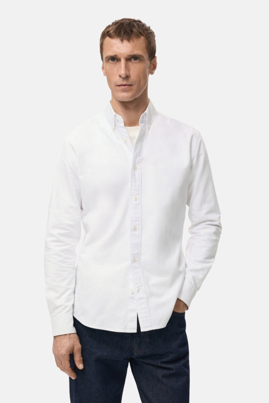 Blouse blanche à manches longues de MANGO, vue de derrière, avec des jeans foncés.
