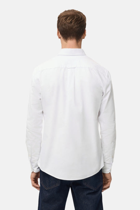 Achterkant van een man in een wit overhemd en donkere jeans.