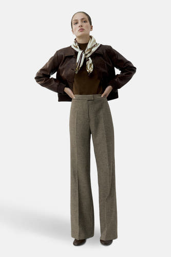 Pantalon multicolore de MANGO, avec un motif pied-de-poule, associé à une veste en cuir marron.