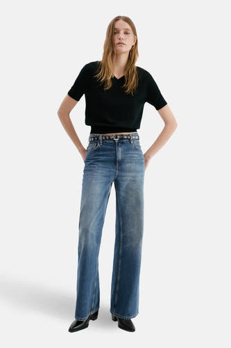 Jean droit en denim bleu moyen de MANGO, porté avec une ceinture noire et des chaussures noires.