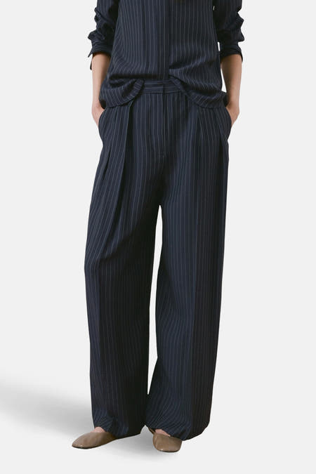 Blauwe broek van MANGO met krijtstreep, wijde pijpen en plooien in de taille.
