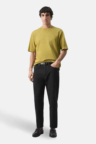 T-shirt à manches courtes vert de MANGO, porté avec un jean noir et des chaussures.