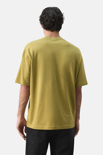 Groen T-shirt met korte mouwen van MANGO, gezien van achteren, gecombineerd met zwarte jeans.
