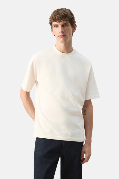 T-shirt écru à manches courtes de MANGO, vu de dos, porté avec un jean foncé.