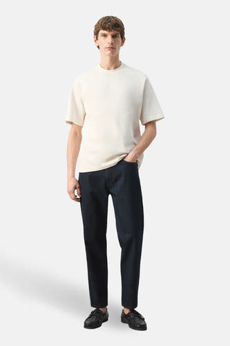 T-shirt écru à manches courtes de MANGO, porté avec un jean foncé et des chaussures noires.