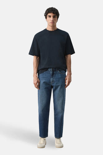 T-shirt bleu à manches courtes de MANGO, porté avec un jean bleu et des chaussures blanches.