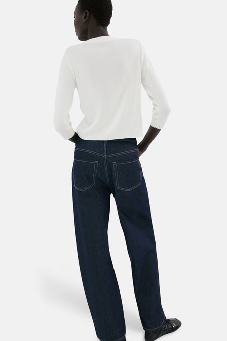 Witte gilet van MANGO, gezien van achteren, gecombineerd met donkere jeans en platte schoenen.