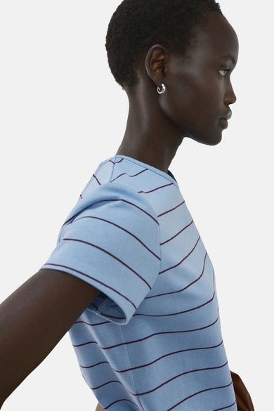 T-shirt bleu rayé de MANGO, à manches courtes, combiné avec une veste marron et un jean foncé ample.