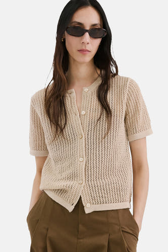 Gilet marron de MANGO, texturé et porté sur un haut crème et un pantalon marron, vu de dos.