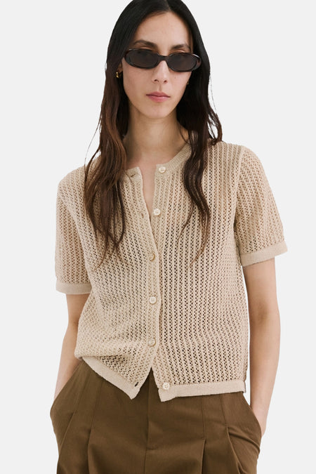 Gilet marron de MANGO, texturé et porté sur un haut crème et un pantalon marron, vu de dos.