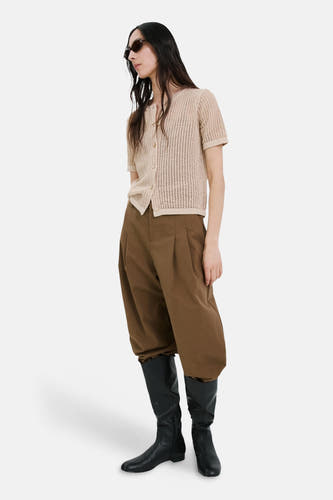Gilet marron de MANGO, combiné avec un pantalon marron et des bottes noires.