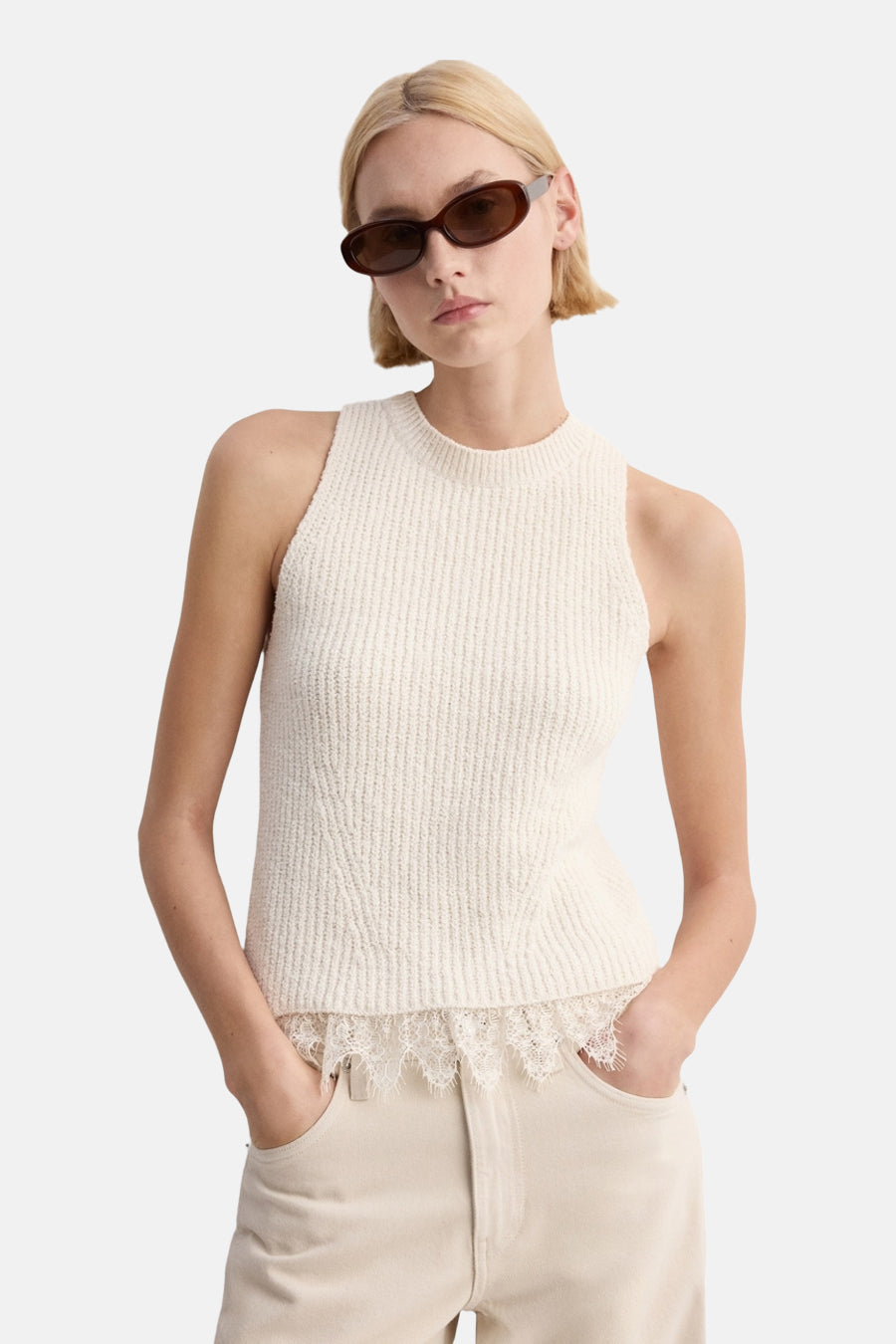 Haut sans manches écru de MANGO, avec des détails en dentelle sur le bas et combiné avec un pantalon ample de couleur crème.