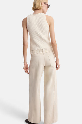 Ecru top zonder mouwen van MANGO, met kanten details aan de onderkant en gecombineerd met een wijde, crèmekleurige broek.