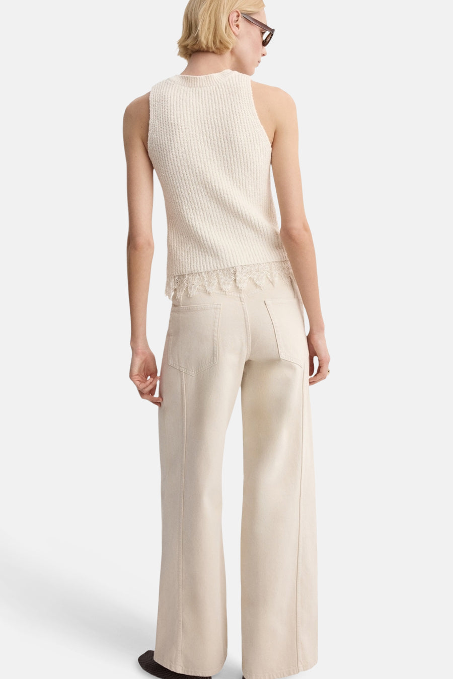 Ecru top zonder mouwen van MANGO, met kanten details aan de onderkant en gecombineerd met een wijde, crèmekleurige broek.