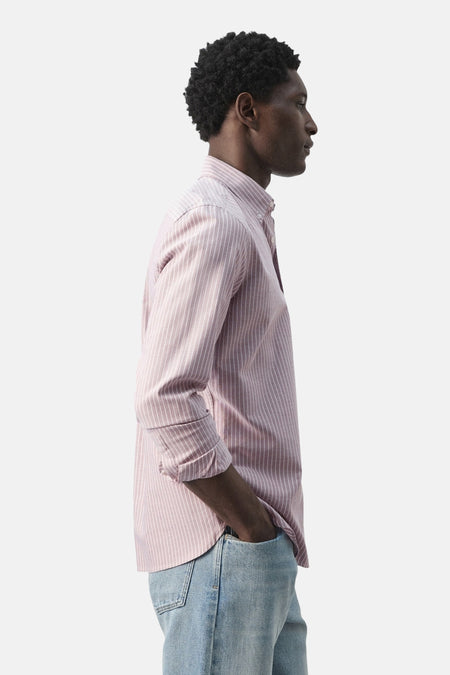 Chemise rose de MANGO à manches longues et fines rayures verticales, vue de côté, associée à un jean bleu.